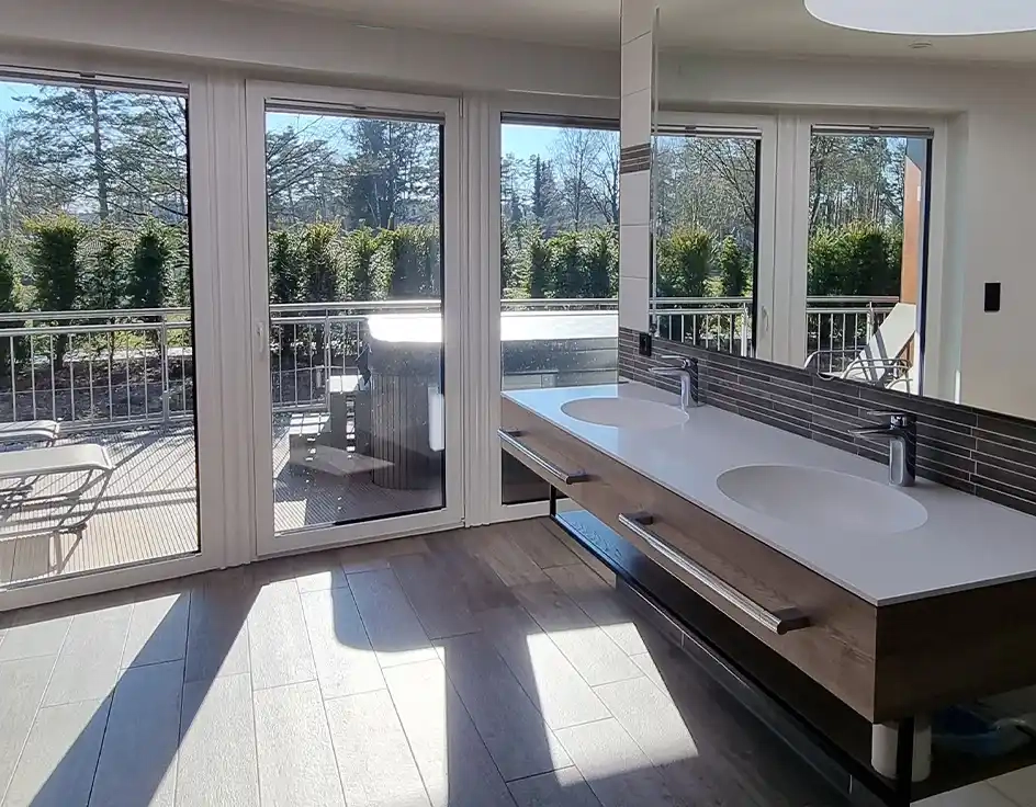 Waschhäuser: die Sanitärgebäude im Südsee-Camp Modernes Privatbad im Waschhaus 4 des Südsee-Camps mit zwei Waschbecken, großer Spiegelwand und direktem Zugang zur privaten Außenterrasse mit Sichtschutz und Whirlpool.