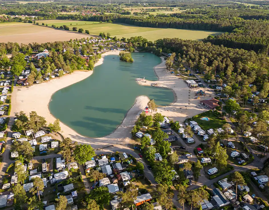 Camping im Südsee-Camp Luftaufnahme vom Südsee-Camp in der Lüneburger Heide mit großem Badesee, Sandstrand, Stellplätzen für Wohnwagen und Wohnmobile sowie umgebenem Wald – familienfreundlicher Campingplatz mit Natur und Freizeitangebot