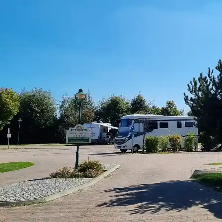 Einfahrt zum Wohnmobilhafen im Südsee-Camp mit Hinweisschild und geparkten Wohnmobilen