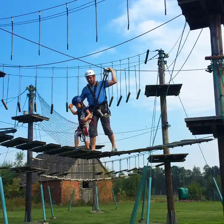 Ein Mann klettert durch einen Hochseilparkour