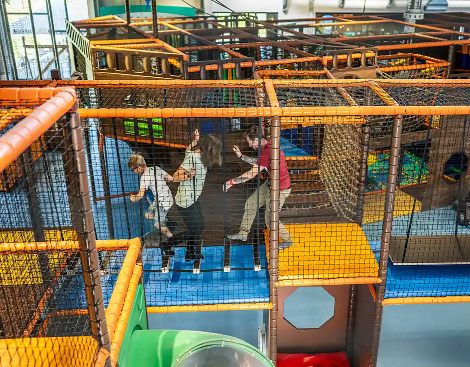 Piratennest - der Indoorspielplatz im Südsee-Camp Wietzendorf Kinder toben durch das große Klettergerüst im Indoor-Spielplatz des Südsee-Camps – sicheres Spielen bei jedem Wetter.