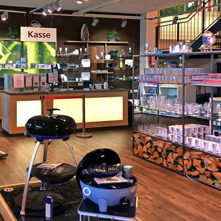 Innenansicht des Camping-Shops im Südsee-Caravans mit Grillzubehör, Geschirr, Gläsern und Kasse – alles für den perfekten Campingurlaub