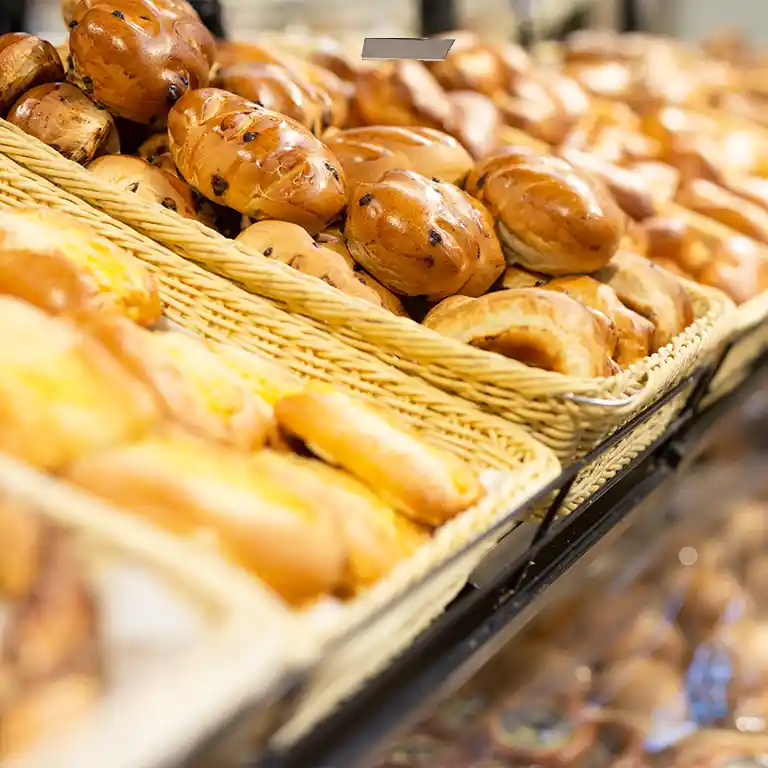 Frisch gebackene Brötchen und süße Teilchen in geflochtenen Körben in der Bäckerei im Südsee-Camp – ideal für ein familienfreundliches Frühstück im Urlaub.