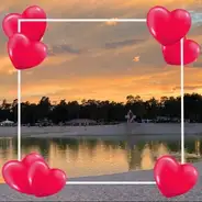 Valentinstag Sonnenuntergang über dem See mit Leuchtturm umgeben von einem Herzrahmen