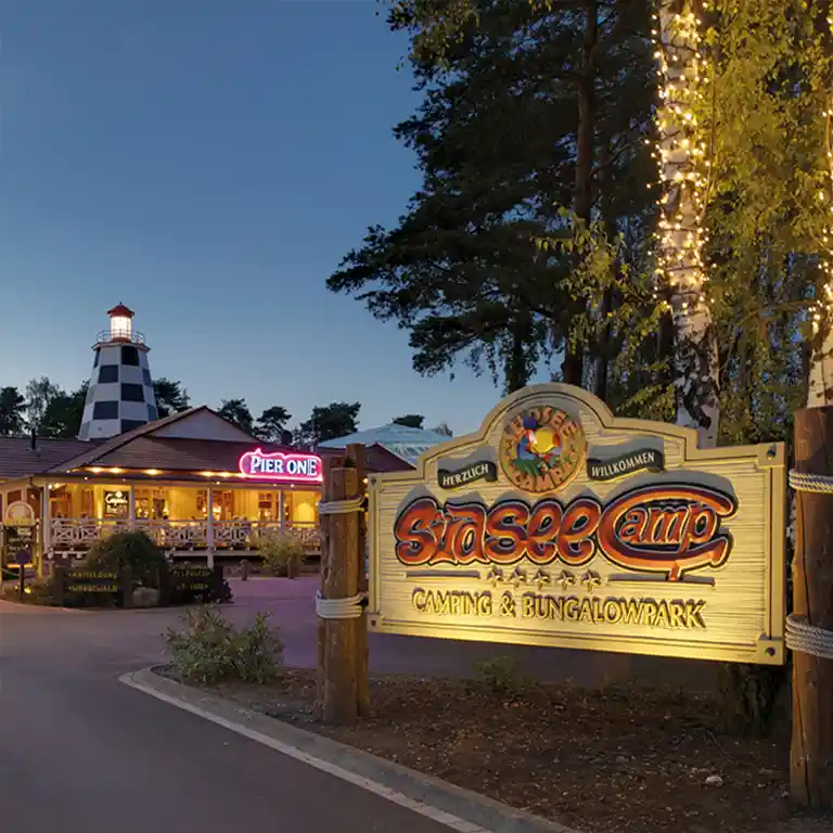 Südsee-Camp Eingangsschild im Halbdunkel