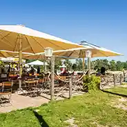 Strandbar & Imbiss Sonnenschirme mit Gartenmöbeln darunter