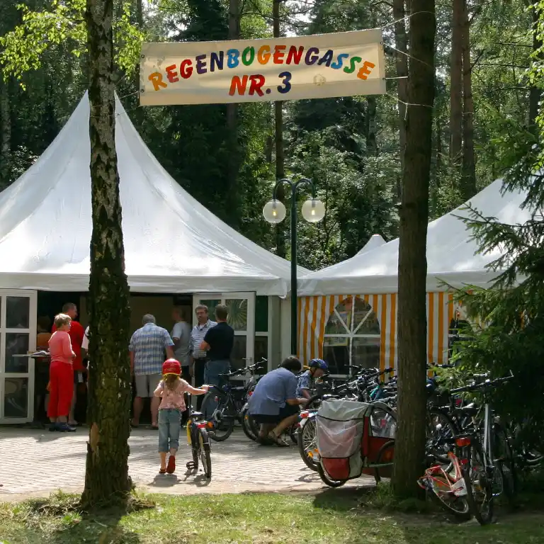 ev. Kirche auf dem Südsee-Camp! Zeltbereich der mobilen „Kirche unterwegs“ mit Fahrrädern und Besuchern im Wald